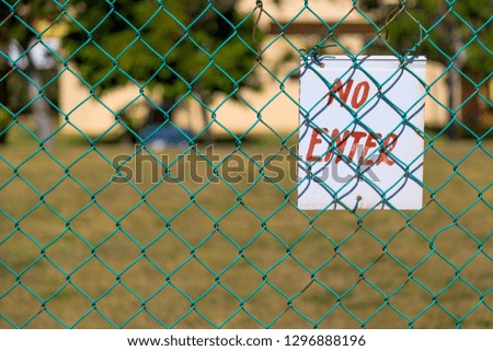 No Enter sign on green fence close up outdoors