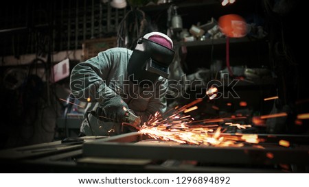 Electric wheel grinding on steel structure in factory.Sparks from the grinding wheel.     