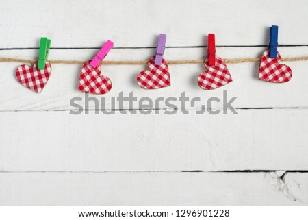 Love hearts hanging on rope on wooden background