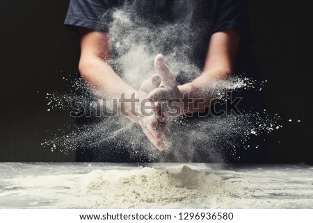 Clap hands of baker with flour in restaurant kitchen Royalty-Free Stock Photo #1296936580