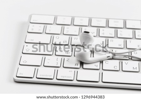 white earphones on white keyboard