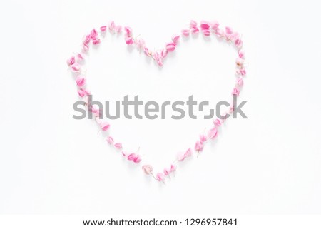 flat lay of floral heart made from pink flowers isolated on white background, top view. flower creative composition