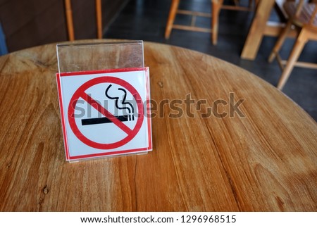 No smoking sign on wooden table in coffee shop.