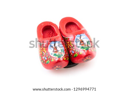 Red painted typical dutch wooden shoes with a picture of a mill on it, facing front