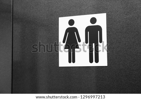 Toilet sign with male and female figures on dark background