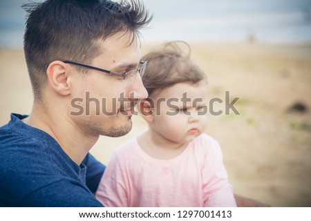 Dad and baby girl on the beach. The concept of educating the father of young children, happy childhood, a friendly family.