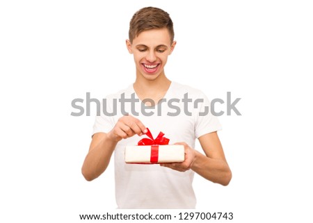 portrait of a guy with a gift, isolate, the guy in a white T-shirt gives a gift