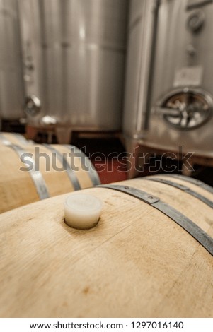 Inside of a modern winery having wine in oak barrels and aluminium tanks