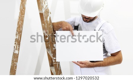 painter man with ladder showing blank white placard, copy space template