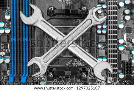 Two wrench crossed on motherboard. Repairing computers.