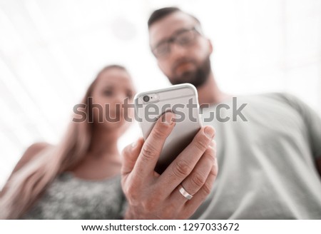 young couple looking photos on smartphone