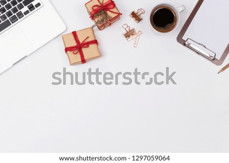 Woman home office desk workspace with notebook, Gift box and coffee cup on white background. Flat lay, Top view. Stylish female concept. Image.