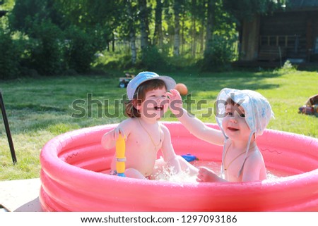Little children bathe in the pool on the street in summer
