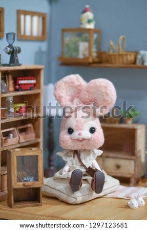 Cute rabbit doll. A pink kawaii rabbit felt doll sitting in living room with vintage setting. Toy photography.