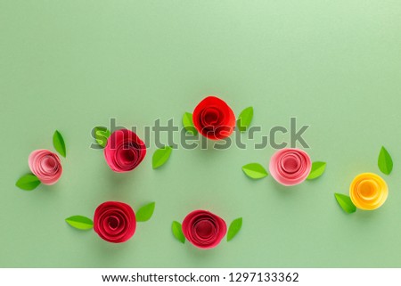Green background with red, pink and yellow roses of paper, decor, spring