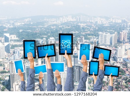 Set of tablets in male hands against modern cityscape background