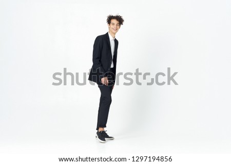 young guy in a classic suit stands in full growth on an isolated background                       