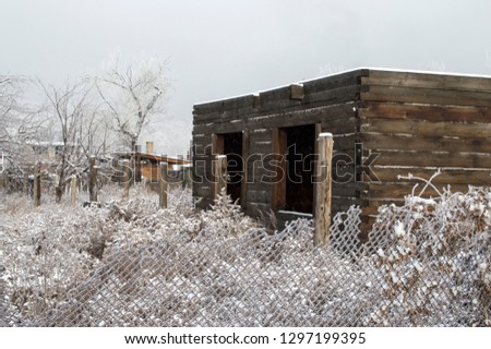 an unfinished lumber house stands in an abandoned garden in the village in winter