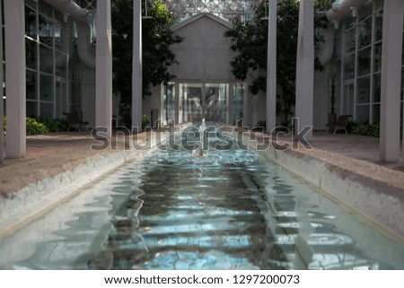 Font with blue water, columns on the sides and white facade background