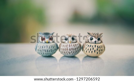 Three owls and their reflection on the marble floor.