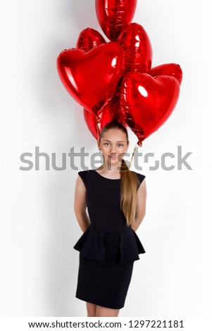 Valentine Beauty young girl, teenager with red air balloon portrait, isolated on background. Beautiful Happy Young kid holding balloons. Holiday party, birthday. Joyful little model - Image