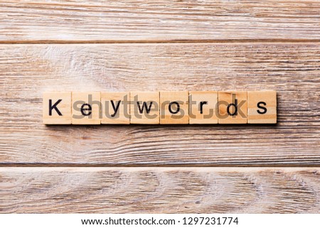 KEYWORDS word written on wood block. KEYWORDS text on wooden table for your desing, concept.