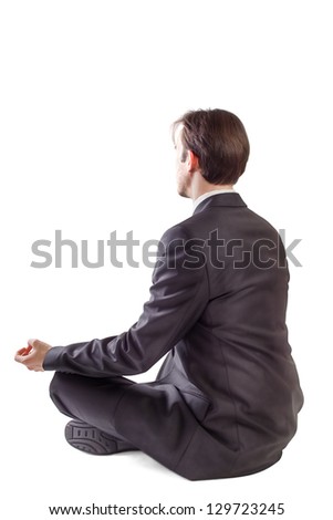 Young man in black suit meditating on white background