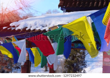 Buddhist tibetan prayer flags is fluttering in wind. Colorful Tibetan flags illuminated by sunset.