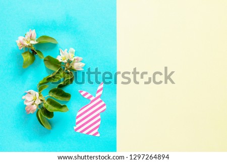 Spring flowers apple-tree trees, Easter bunny on a blue and yellow background. Minimal easter concept. Flat lay, top view background.