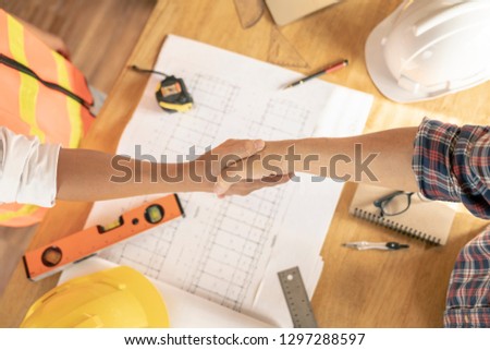 team of architect discuss about problem of house or building in office,plan is fake only for stock photo.

