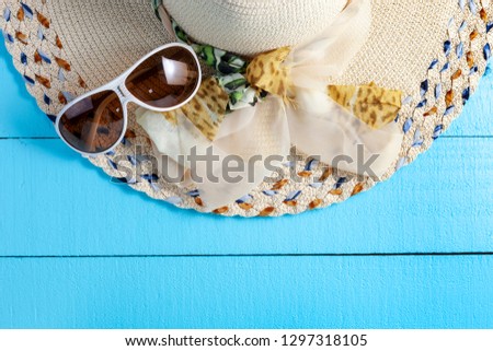 Flat lay of beautiful lady hat beach on wood background.