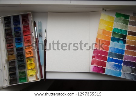 Artistic creative design workspace, sketchbook. Set of tools for a watercolor painting, brushes, palletes, paint