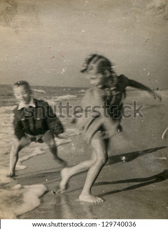Vintage photo of children running on beach (visible motion blur) - fifties