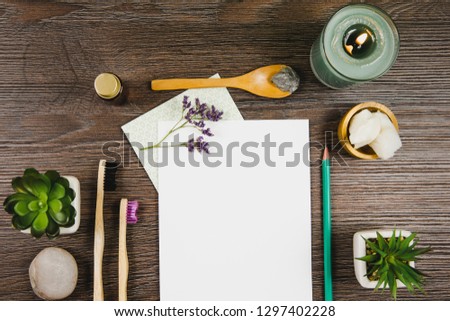 Natural nature friendly beauty products blogger concept. Various skin care treatment products on dark brown wooden table background, top view. Empty white sheet of paper in center.