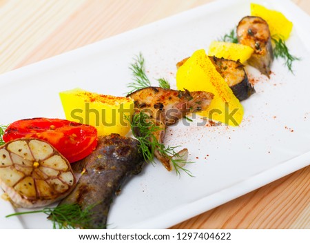 Picture of  deliciously baked rainbow trout  steaks with potatoes  on white plate