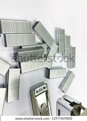White stapler and staples on a white background