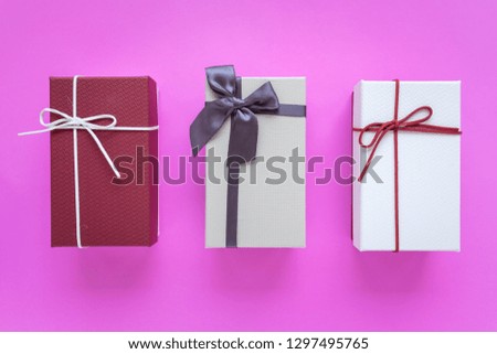 Gift box with ribbon bow isolated on pink background