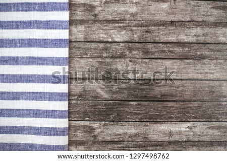Old wooden table with a blue striped tablecloth. Table setting's concept.