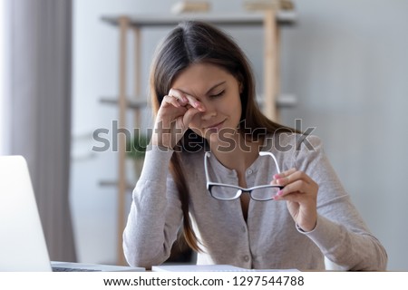 Tired student or worker rubbing irritable eyes feeling fatigue from computer work concept, overworked woman taking off glasses to relieve eye strain suffering from bad eyesight vision problem concept Royalty-Free Stock Photo #1297544788