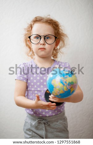 A Little Girl Studying The Globe. concept of education