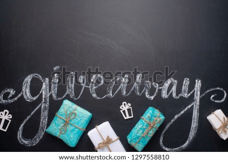 The inscription giveaway written on a blackboard with gifts. The distribution of gifts