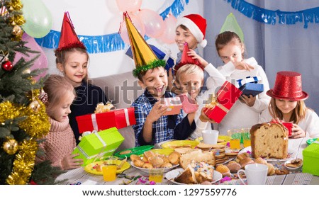 positive american children presenting gifts during Christmas dinner