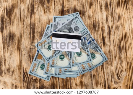 Dollar banknotes with credit card on wooden desk