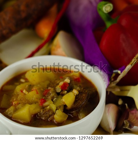 Traditional Hungarian goulash with beef, potatoes, tomatoes and peppers, a tasty dish in a white bowl, nutritious dish