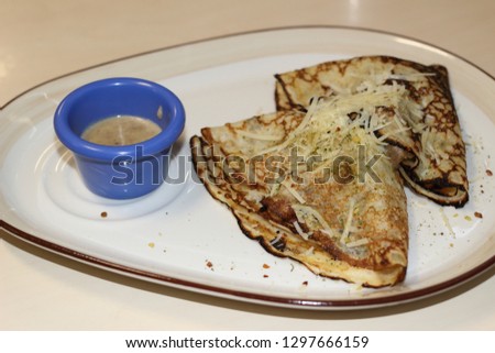 Very appetizing pancakes with meat filling and sauce on a flat plate. Delicious and nutritious breakfast