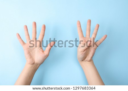 Woman showing sign nine on color background, closeup. Body language