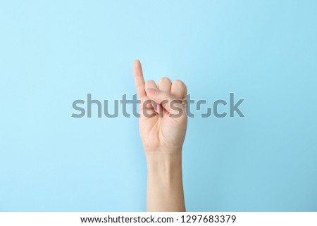 Woman showing I letter on color background, closeup. Sign language