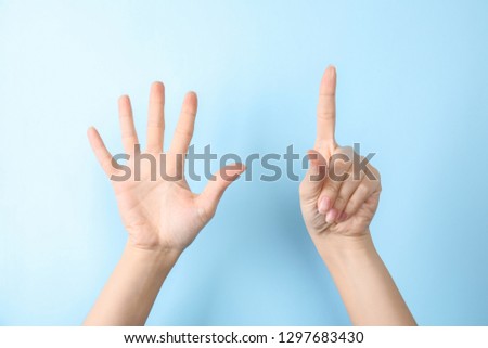 Woman showing sign six on color background, closeup. Body language