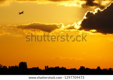 plane taking off from Brussels airport at sunset  Royalty-Free Stock Photo #1297709473