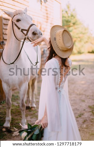cowboy style bride stands with her back to camera